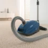Miele Complete C3 Petrol Blue vacuum cleaner on a cream carpet